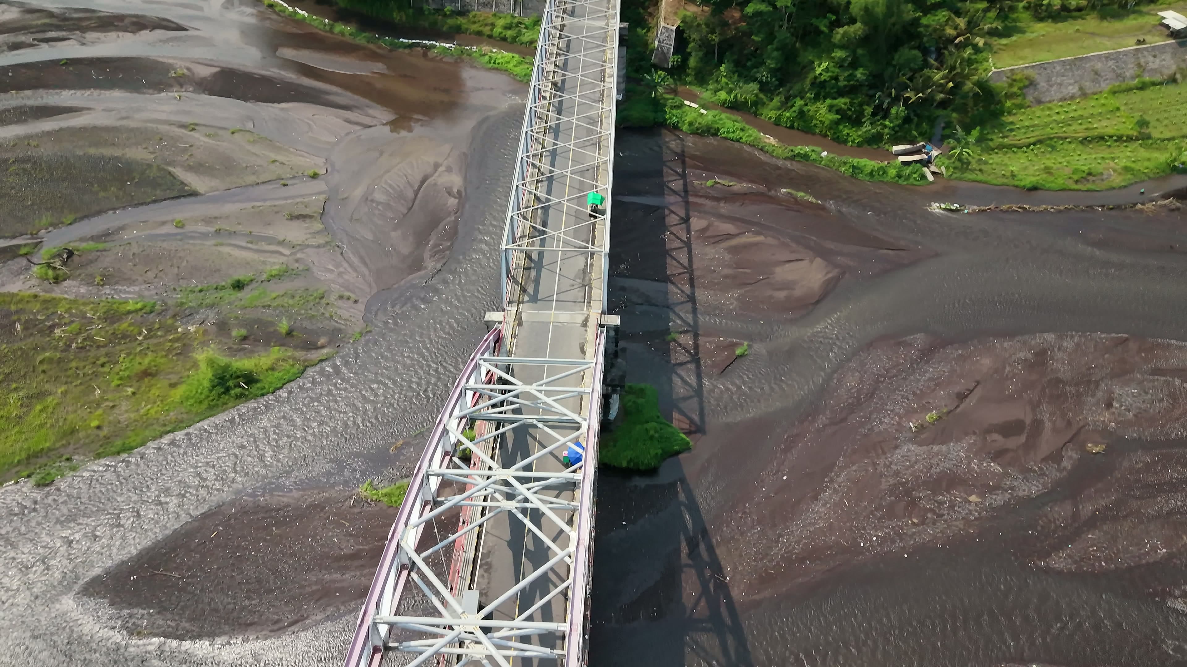 An old truss bridge crossing a volcanic riverbed, Indonesia